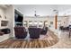 A living room with hardwood floors, a ceiling fan, and large windows overlooking the backyard at 5221 N Tuthill Rd, Litchfield Park, AZ 85340