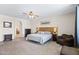 A spacious bedroom features a wood accent wall, ceiling fan and natural light at 5221 N Tuthill Rd, Litchfield Park, AZ 85340