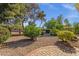 Large backyard with mature trees, gravel landscaping, and a glimpse of the brick-lined patio at 5353 W Dublin Ct, Chandler, AZ 85226