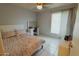 Bright bedroom with a floral comforter on the bed, a vanity, a ceiling fan, and tile flooring at 6546 N 71St Ave, Glendale, AZ 85303