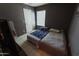 Bedroom featuring twin beds, a window, gray walls, and tile flooring, offering a cozy and simple design at 6546 N 71St Ave, Glendale, AZ 85303