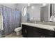 Bathroom featuring a double sink vanity with black cabinets and a unique, circular shower window at 6565 E Thomas Rd # 1128, Scottsdale, AZ 85251