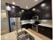 Modern kitchen features black cabinets, stainless appliances, and an island at 6565 E Thomas Rd # 1128, Scottsdale, AZ 85251
