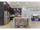 Modern kitchen features stainless steel appliances, dark cabinets, an island, and bar seating at 6565 E Thomas Rd # 1128, Scottsdale, AZ 85251
