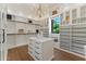 Spacious walk-in closet with custom shelving, drawers, a chandelier, and an island for optimal organization at 7501 N Eucalyptus Dr, Paradise Valley, AZ 85253