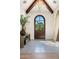 Elegant entryway features a wooden arched door, herringbone tile floors, and stylish decor at 7501 N Eucalyptus Dr, Paradise Valley, AZ 85253