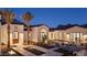 Elegant home exterior with meticulously manicured landscaping, inviting fire pit area, and warm exterior lighting at 7501 N Eucalyptus Dr, Paradise Valley, AZ 85253