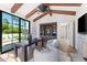 Bright home office with vaulted ceilings, wood beams, and a black framed window overlooking palm trees at 7501 N Eucalyptus Dr, Paradise Valley, AZ 85253