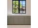 Modern kitchen featuring a large window with a view of lush greenery and custom cabinets with gold hardware at 7501 N Eucalyptus Dr, Paradise Valley, AZ 85253