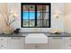 Farmhouse sink, herringbone tile backsplash, gold faucet and hardware, and black trimmed window with mountain views at 7501 N Eucalyptus Dr, Paradise Valley, AZ 85253
