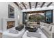 Elegant living room boasts beamed ceilings, a stone fireplace, and expansive sliding glass doors to a covered patio at 7501 N Eucalyptus Dr, Paradise Valley, AZ 85253