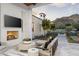 Relaxing outdoor living space featuring a fireplace, comfortable seating, and views of the meticulously landscaped backyard at 7501 N Eucalyptus Dr, Paradise Valley, AZ 85253