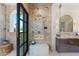 Elegant shower featuring marble tile, dual shower heads, a built-in bench and niche, and glass doors at 7501 N Eucalyptus Dr, Paradise Valley, AZ 85253