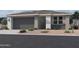 Charming single-story home featuring a gray garage door, desert landscaping, and a welcoming entrance at 7604 W Saddlehorn Rd, Peoria, AZ 85383