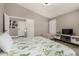 Stylish bedroom featuring a floral-patterned bedspread, modern TV console, and neutral wall color at 7810 W Beryl Ave, Peoria, AZ 85345