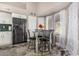 Eat-in kitchen features a modern black fridge and a glass-topped dining table with seating for four at 7810 W Beryl Ave, Peoria, AZ 85345