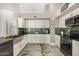 Modern kitchen features a stainless steel apron sink, green tiled backsplash, and sleek black countertops at 7810 W Beryl Ave, Peoria, AZ 85345