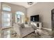 Cozy living room boasts vaulted ceilings, a stylish TV console, and lots of natural light from the arched window at 7810 W Beryl Ave, Peoria, AZ 85345