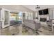 Bright living room featuring a fireplace, patio doors opening to a pool, and polished, painted concrete floors at 7810 W Beryl Ave, Peoria, AZ 85345