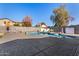 Backyard pool features lounge chairs and umbrellas for relaxing on the large concrete patio at 7810 W Beryl Ave, Peoria, AZ 85345