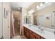 Bathroom featuring double sinks, walk in shower, and large mirror at 7936 S 7Th Way, Phoenix, AZ 85042