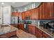 Stylish kitchen featuring granite countertops, cherry wood cabinets, stainless steel appliances, and tile floors at 7936 S 7Th Way, Phoenix, AZ 85042