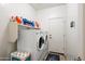 Well-lit laundry room with washer, dryer, storage shelf, and exterior access door at 7936 S 7Th Way, Phoenix, AZ 85042