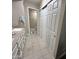 Well-lit bathroom featuring double vanity, tiled floors, and a closet with sliding doors at 839 S Westwood S -- # 169, Mesa, AZ 85210