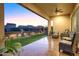 Relaxing backyard with covered patio, green lawn, desert landscaping, and twilight views at 8691 E Eastwood Cir, Carefree, AZ 85377