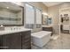 Bright bathroom featuring dual vanities, soaking tub, and spacious walk-in shower and closet at 8691 E Eastwood Cir, Carefree, AZ 85377
