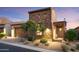 Charming stone-accented home featuring a well-manicured front yard and inviting front porch at 8691 E Eastwood Cir, Carefree, AZ 85377