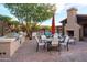 Outdoor kitchen and dining area with built-in grill, fireplace, and views of the pool at 8691 E Eastwood Cir, Carefree, AZ 85377