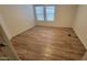 Bright bedroom with wood-look laminate flooring, white walls, and natural light at 8854 W Aster Dr, Peoria, AZ 85381