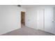 Bedroom featuring carpeted flooring, sliding closet doors, and an open doorway to the hall at 8854 W Aster Dr, Peoria, AZ 85381