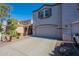 Townhome featuring a two-car garage, long driveway, and desert landscaping at 8854 W Aster Dr, Peoria, AZ 85381