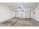 An empty two-car garage with a standard garage door and neutral walls, offering ample storage space at 8854 W Aster Dr, Peoria, AZ 85381