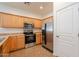 Kitchen with stainless steel appliances, wooden cabinets, and tile flooring at 8854 W Aster Dr, Peoria, AZ 85381