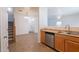 Kitchen with stainless steel dishwasher, tile flooring, and view into the dining and living spaces at 8854 W Aster Dr, Peoria, AZ 85381