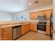 Kitchen featuring tile flooring, stainless steel appliances, wooden cabinets and a sink below a window at 8854 W Aster Dr, Peoria, AZ 85381