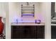 Sophisticated bar area featuring granite countertops, custom cabinetry, and decorative lighting at 9342 W White Feather Ln, Peoria, AZ 85383