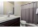 Neutral bathroom showcasing the vanity, toilet, shower with curtain and decor details at 9342 W White Feather Ln, Peoria, AZ 85383