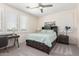 Bright bedroom featuring neutral decor, plantation shutters, and a functional desk area at 9342 W White Feather Ln, Peoria, AZ 85383