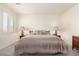 Calm bedroom with a plush bed, neutral tones, carpeted floors, lamps, and a window for natural light at 9342 W White Feather Ln, Peoria, AZ 85383