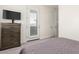 Bedroom with dresser, TV, plantation shuttered window and access to the exterior at 9342 W White Feather Ln, Peoria, AZ 85383