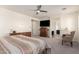 A spacious bedroom that features a bed, a ceiling fan, and a doorway to an ensuite bathroom at 9342 W White Feather Ln, Peoria, AZ 85383