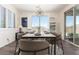 Bright dining room with a marble table, elegant chandelier, and natural light from a large window at 9342 W White Feather Ln, Peoria, AZ 85383