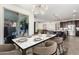 Modern dining room with marble table, stylish chandelier, and access to outdoor patio at 9342 W White Feather Ln, Peoria, AZ 85383