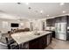 Bright kitchen featuring dark cabinets, a stainless steel fridge, a kitchen island, and an open layout at 9342 W White Feather Ln, Peoria, AZ 85383