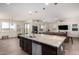 Open concept kitchen with an island, stainless steel appliances, and a view to the living area and backyard at 9342 W White Feather Ln, Peoria, AZ 85383