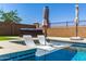 Inviting backyard pool featuring sun loungers and umbrellas for relaxation on a sunny day at 9342 W White Feather Ln, Peoria, AZ 85383